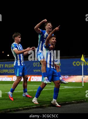 Stefanos Tzimas di Brighton e Hove Albion (a destra) festeggia con Harry Howell di Brighton e Hove Albion (a sinistra) e Brajan Gruda di Brighton e Hove Albion (al centro) dopo aver segnato il quarto gol ai suoi lati durante la partita del secondo turno della Carabao Cup all'Hill Kassam Stadium di Oxford. Data foto: Mercoledì 27 agosto 2025. Foto Stock