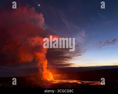 Dalla caldera del cratere di Halemaumau fuoriesce una fontana di lava calda che si getta sul fondo della caldera al crepuscolo, il vulcano Kilauea, l'isola delle Hawaii, Stati Uniti Foto Stock