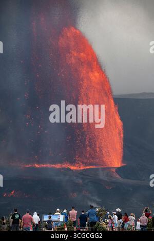 I visitatori si riuniscono in un punto panoramico per ammirare le fontane di lava calda che si estendono a 1000 metri dal cratere Halemaumau, dal vulcano Kilauea, dall'HVNP, dall'Isola delle Hawaii, Stati Uniti Foto Stock
