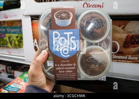Los Angeles, California, Stati Uniti - 02-19-2020: Una mano contiene un pacchetto di pentole e Co., torte di cioccolato e caramello salato Lava, presso il negozio. Foto Stock