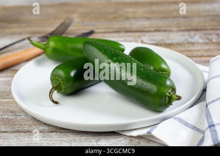 Vista di un piatto di peperoni jalapeno verdi freschi. Foto Stock