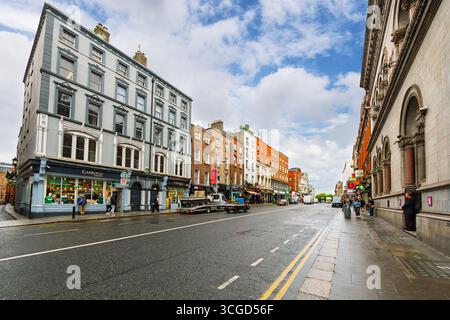 Edifici storici fiancheggiati da pub e negozi lungo Dame Street, a Temple Bar, Dublino, Irlanda, dopo una doccia estiva a pioggia. Foto Stock