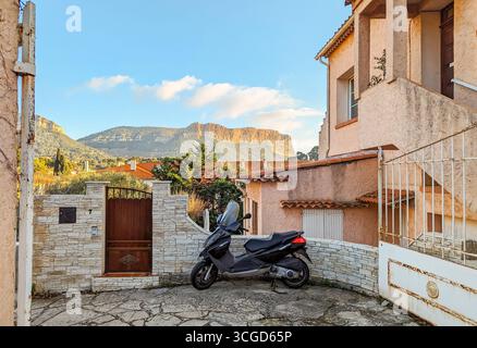 Vista delle scogliere costiere di Cap Canaille del Parco Nazionale delle Calanques da un cortile residenziale nella pittoresca cittadina costiera di Cassis, Francia. Foto Stock