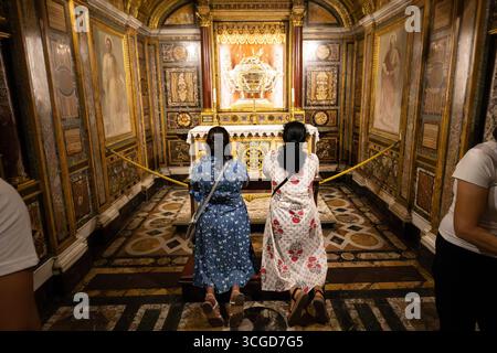 Le donne pregano in ginocchio di fronte alla "Sacra culla", una delle reliquie trovate sotto l'altare maggiore della Basilica di Santa Maria maggiore. L'anno giubilare 2025 proclamato da Papa Francesco sotto il tema "pellegrini della speranza", cerca di trasmettere un messaggio di speranza a un mondo segnato dalla guerra e dalla crisi. I fedeli sono chiamati al rinnovamento spirituale con particolare attenzione alla solidarietà e alla carità verso gli altri. Secondo la tradizione cristiana, i pellegrini possono ottenere un'indulgenza plenaria attraverso viaggi a Roma, atti di carità e passando attraverso una delle quattro "porte sante" della città. Foto Stock