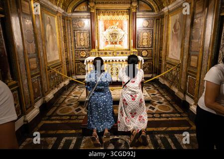Roma, Lazio, Italia. 24 agosto 2025. Le donne pregano in ginocchio di fronte alla "Sacra culla", una delle reliquie trovate sotto l'altare maggiore della Basilica di Santa Maria maggiore. L'anno giubilare 2025 proclamato da Papa Francesco con il tema "pellegrini della speranza", cerca di trasmettere un messaggio di speranza a un mondo segnato dalla guerra e dalla crisi. I fedeli sono chiamati al rinnovamento spirituale con particolare attenzione alla solidarietà e alla carità verso gli altri. Secondo la tradizione cristiana, i pellegrini possono ottenere un'indulgenza plenaria attraverso viaggi a Roma, atti di carità e passando attraverso uno di essi Foto Stock