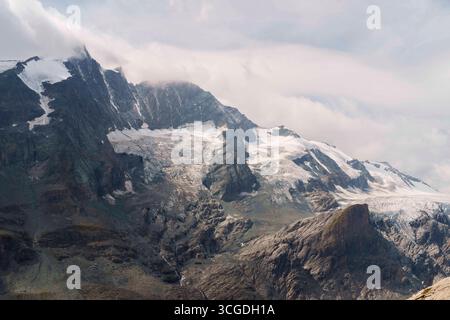 Il Grossglockner e il ghiacciaio Pasterze sono visti dal Gamsgrubenweg vicino alla Grossglockner Hochalpenstrasse, conosciuta anche come Grossglockner High Alpine Road. È la strada di passo di montagna più alta dell'Austria, che prende il nome dalla montagna più alta dell'Austria. Heiligenblut Carinzia Austria Foto Stock