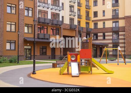 Parco giochi per bambini nel cortile di un edificio a più piani Foto Stock