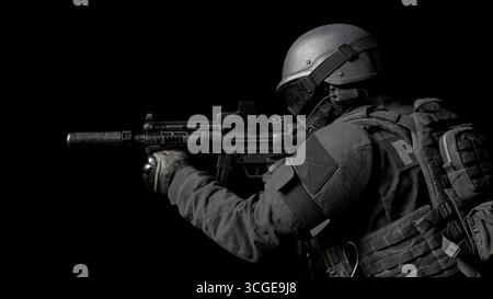 soldier è equipaggiato con un'arma da fuoco e mostra una posizione tattica in un ambiente buio. la scena mette in evidenza la dedizione dei soldati all'addestramento e alla prontezza f Foto Stock
