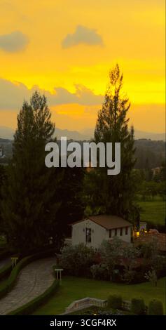 Vista del tramonto sulle idilliache ville di campagna, circondate da lussureggianti Foto Stock