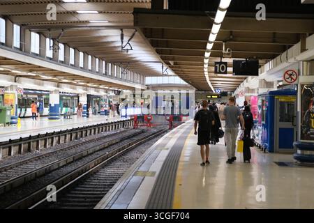 Le persone camminano lungo il binario 10 della stazione ferroviaria di Euston, Londra Foto Stock