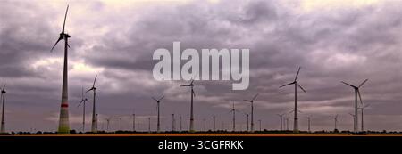 Turbine eoliche alte in un campo in germania, che generano energia rinnovabile sotto un cielo nuvoloso Foto Stock