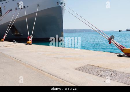 Ormeggio di una nave nel porto utilizzando linee di ormeggio fino a un dissuasore sulla banchina Foto Stock