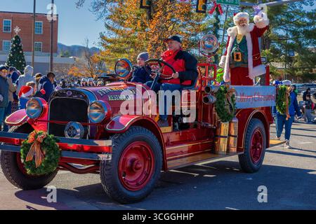 Johnson City, Tennessee, Stati Uniti - 7 dicembre 2024: Un vecchio furgone dei vigili del fuoco con Babbo Natale in piedi sul retro che saluta alla folla durante il giorno Foto Stock