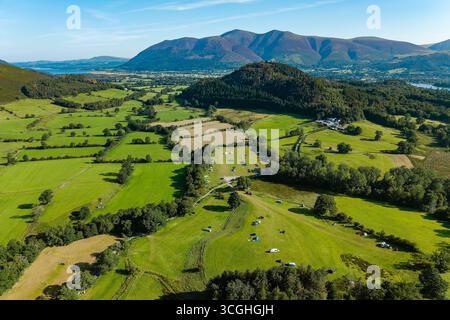 Tende e camper nei campi verdi circondati da colline vicino a Keswick, in Inghilterra Foto Stock