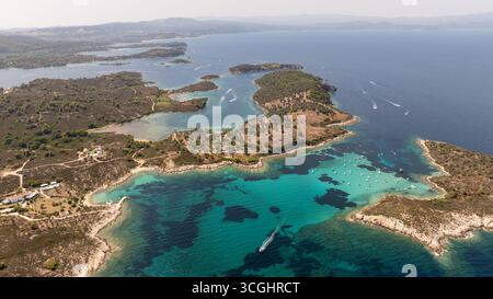 Splendida prospettiva aerea che cattura le ipnotiche acque turchesi, la vegetazione lussureggiante e le idilliache isole di Vourvourou a Sithonia, in Grecia Foto Stock