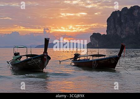 Barche a coda lunga al tramonto a West Railay Beach, Krabi, Thailandia Foto Stock