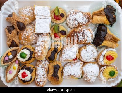 Varietà di dolci italiani dolci dolci dolci dolci dolci e torte con panna e frutta su piatto realizzati in panetteria artigianale a Roma, Italia, primo piano Foto Stock