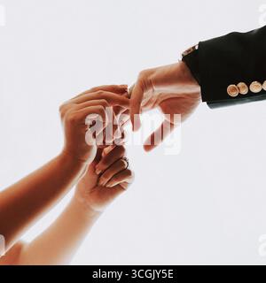 Anelli per lo scambio di mani da sposa e sposo su sfondo bianco minimale Foto Stock