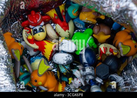 Ipoh, Malesia – 17 agosto 2025: Un variopinto assortimento di giocattoli di seconda mano, tra cui action figure, personaggi dei cartoni animati e oggetti da collezione Foto Stock