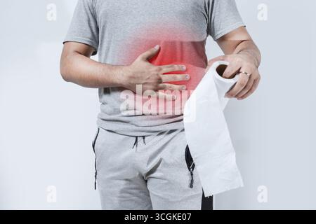 Persona con problemi digestivi che tiene la carta igienica isolata. Concetto di malattia digestiva Foto Stock