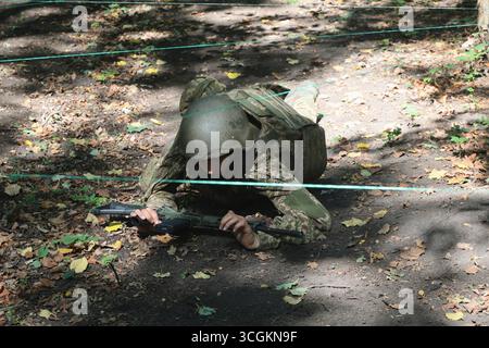 Un fanteria del battaglione operativo della 13a Brigata operativa della Guardia nazionale Ucraina della Khartiia strizza sotto le corde lungo la rotta ad ostacoli durante una sessione di addestramento al tiro, regione di Charkiv, Ucraina, 28 agosto 2025. (Foto di Viacheslav Madiievskyi/Ukrinform) Foto Stock