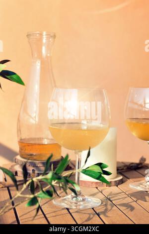 Bicchieri di vino bianco fresco con una bottiglia aperta sul tavolo Foto Stock