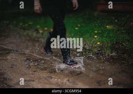 Il ragazzo gioca a Muddy Puddles Foto Stock