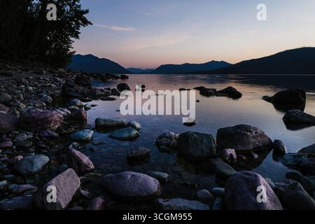 Tramonto sulla costa del lago Rocky con riflessi delicati Foto Stock