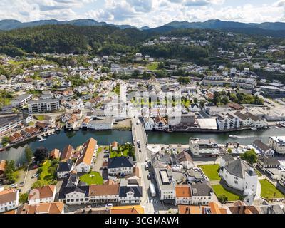 Vista aerea del tranquillo canale che riflette i pittoreschi edifici e il ponte che collega entrambi i lati della città, Flekkefjord, Agder, Norvegia. Foto Stock
