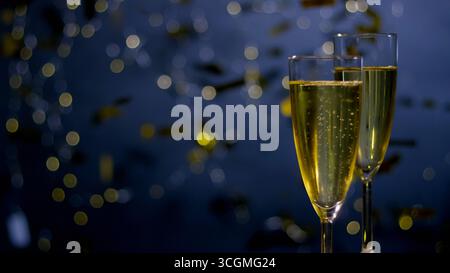 Due bicchieri di bibita frizzante seduti fianco a fianco, con decorazioni festose che suggeriscono una celebrazione. Foto Stock