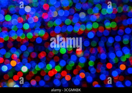 Sfocate ghirlanda multicolore con luci incandescenti. Natale, capodanno, festa di compleanno e concetto di matrimonio . Sfondo sfocato, coloratissime lampadine, l Foto Stock