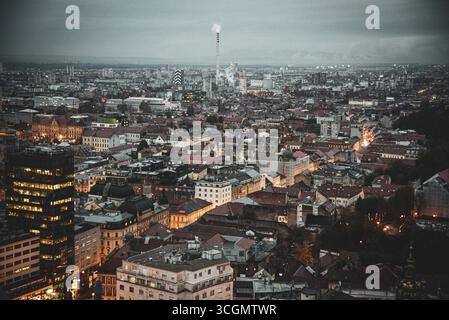 Veduta aerea dell'arazzo della città, dove luci calde lampeggiano contro il fresco crepuscolo, illuminando il paesaggio urbano, la cattedrale di Zagabria si erge alta, Zagabria, Zagabria, Croazia. Foto Stock