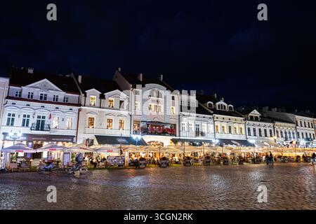 Rzeszow, Polonia - 22 agosto 2025: Piazza del mercato di Rzeszow di notte con facciate illuminate e vivaci attività di strada Foto Stock