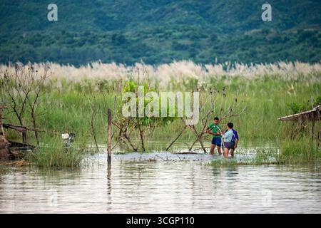 Pescatori che preparano le reti Mandalay Ayeyarwaddy River Myanmar // MANDALAY, Myanmar — i pescatori stanno preparando reti nelle acque del fiume Ayeyarwady (noto anche come Irrawaddy) vicino a Mandalay. Questo vitale corso d'acqua, che scorre attraverso la regione di Mandalay, è centrale per l'economia e la cultura del Myanmar. Il fiume supporta diversi ecosistemi e fornisce mezzi di sussistenza essenziali per le comunità attraverso la pesca, i trasporti e l'agricoltura. L'Ayeyarwady è il fiume più lungo del Myanmar, che si estende per circa 2.170 chilometri (1.350 miglia) da nord a sud. Foto Stock