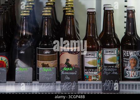 moskow russia, 25.04.2019 Una varietà di bottiglie di birra artigianale in vetro con etichette uniche e cartellini dei prezzi esposti su uno scaffale di un negozio. Foto Stock