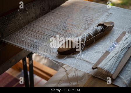 Tradizionale telaio per tessitura in legno con navetta e fili - foto di artigianato tessile Foto Stock
