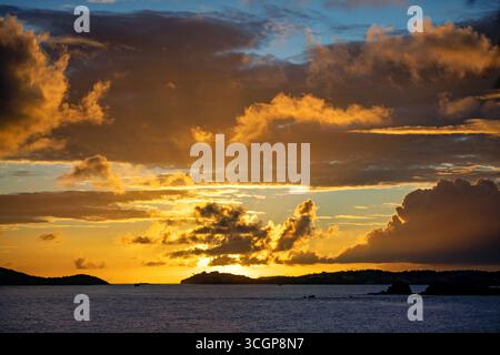 Tramonto su San Tommaso da Gallows Point Cruz Bay St John USVI // ST JOHN USVI - Un tramonto illumina il cielo con nuvole spettacolari come si vede da Gallows Point nella Cruz Bay. In lontananza, l'isola di San Tommaso è visibile all'orizzonte. Le acque del Mar dei Caraibi si estendono in primo piano. Gallows Point è un luogo popolare a St. John, noto per le sue vedute panoramiche delle isole e delle acque circostanti. Foto Stock