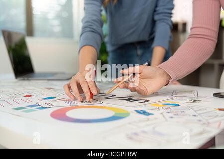 Sessione di progettazione collaborativa UX e UI. Progettisti che lavorano insieme su strutture a reticolo e prototipi. Foto Stock