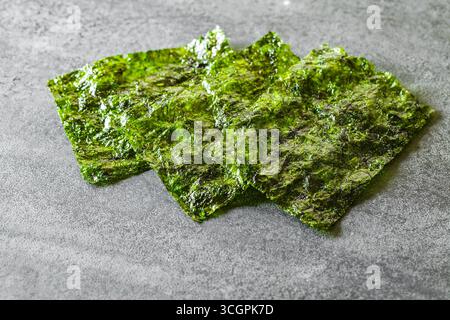 foglie di nori verdi essiccate sul tavolo, messa a fuoco selettiva Foto Stock