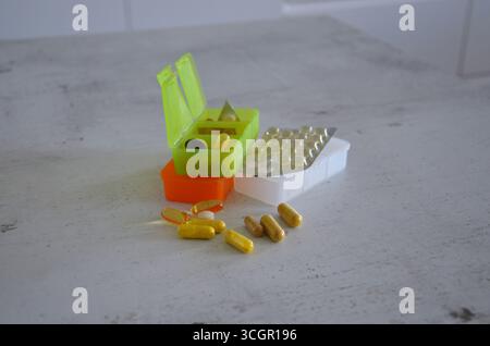 Pillole e compresse sparse sul tavolo Foto Stock