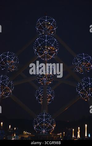 Vista notturna dell'Atomium a Bruxelles, Belgio. Sfere illuminate del famoso monumento architettonico che brillano contro il cielo scuro. Foto Stock