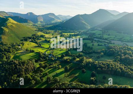 Paesaggio montano panoramico con colline verdi ondulate e lunghe ombre nel Lake District Foto Stock