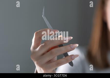 Primo piano di strumenti professionali per manicure che lavorano su eleganti unghie color beige nel salone Foto Stock