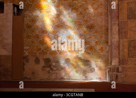 Una parete decorata con arabeschi con luce che si riversa sulla parete Foto Stock
