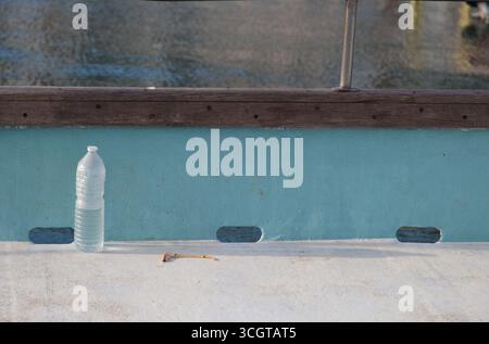 Una vecchia bottiglia di plastica su una barca Foto Stock
