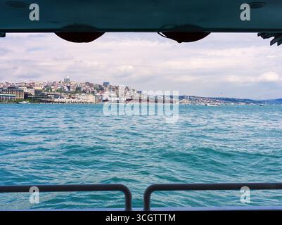 Vista del paesaggio urbano di Istanbul e dello stretto del Bosforo da un traghetto, incorniciato dalla struttura della barca Foto Stock