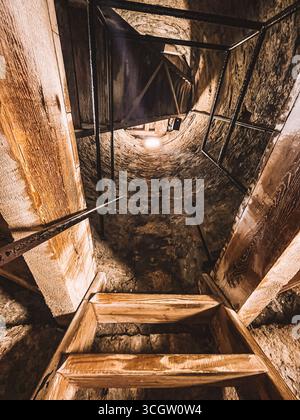 Kilkenny Irlanda, luglio 2023 Scala in un buio e stretto tunnel. La scala è fatta di legno ed è piuttosto stretta a Kilkenny, Irlanda Foto Stock