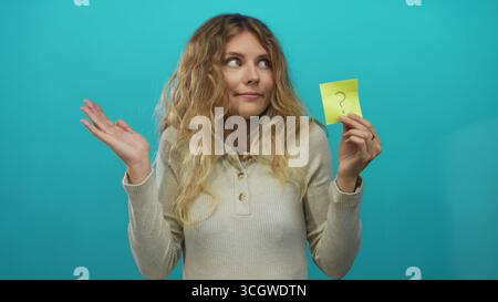 Donna che tiene a mano lo studio bionda giovane appiccicoso appiccicoso appiccicoso domanda turchese evoca curiosità. Foto Stock