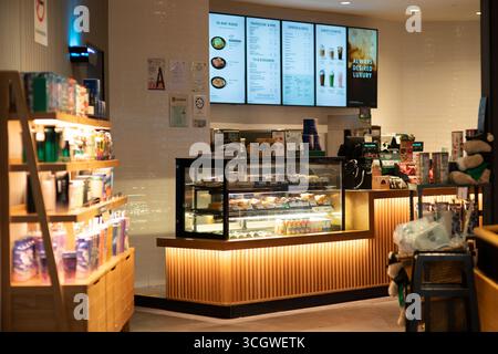 Kuala Lumpur, Malesia - 21 settembre 2024: Un'area al dettaglio all'interno di un bar Starbucks presso KLIA2. Il display include tazze, bevande in bottiglia e sna Foto Stock