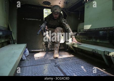 Un fante del battaglione operativo della 13a brigata della Guardia nazionale Ucraina “Khartiia” sale nel compartimento delle truppe di un vettore americano M113 di personale corazzato rintracciato durante l’esercitazione di addestramento aereo, regione di Charkiv, Ucraina, il 29 agosto 2025 (foto di Viacheslav Madiievskyi/Ukrinform) Foto Stock
